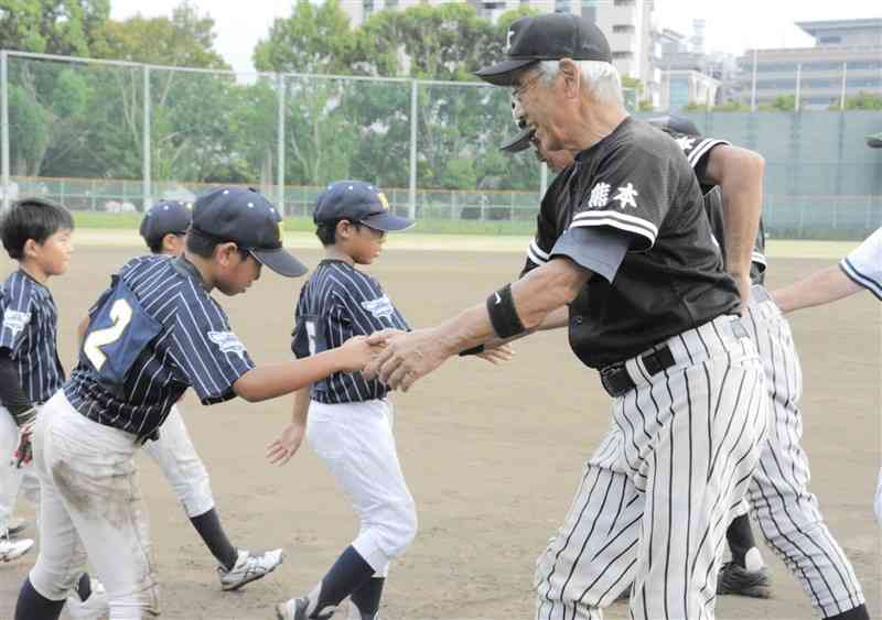 試合終了後、健闘をたたえ合う古希チームと小学生チームの選手たち＝熊本市中央区