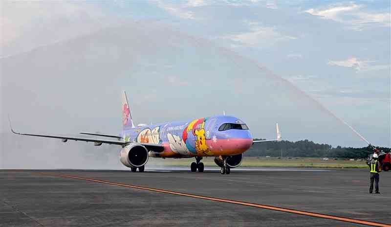 放水のアーチで歓迎されながら熊本空港に到着したチャイナエアライン（中華航空）の第1便＝18日午後5時30分ごろ、益城町（谷川剛）