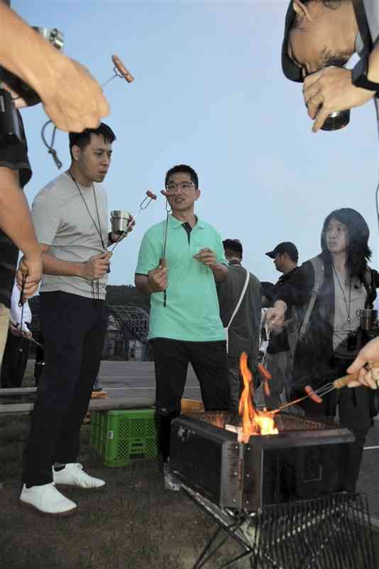 イノシシの肉を使ったソーセージなどを堪能する台湾の青年団員ら＝宇城市