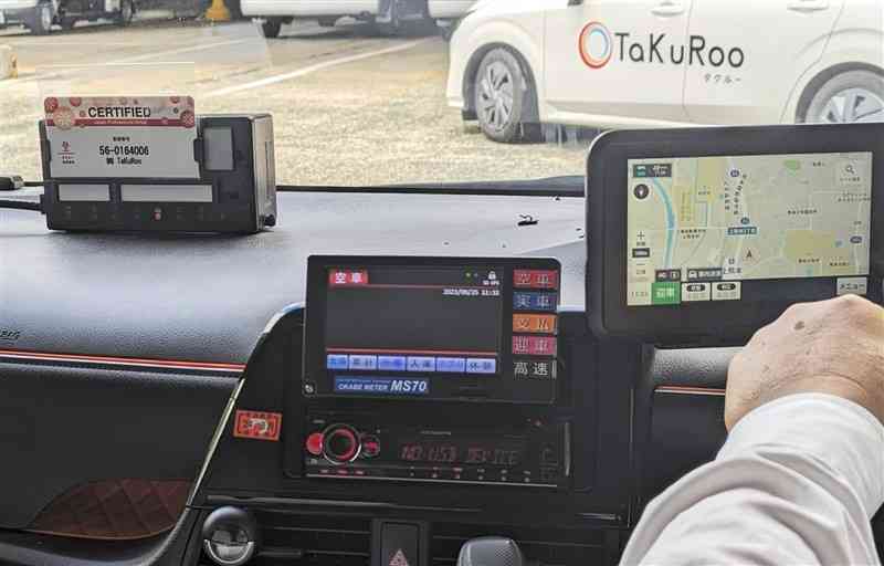 タクシー車内の新様式の運転者証（写真左上）。登録番号を記した面を掲示し、氏名や顔写真は乗客から見えない＝25日、熊本市西区