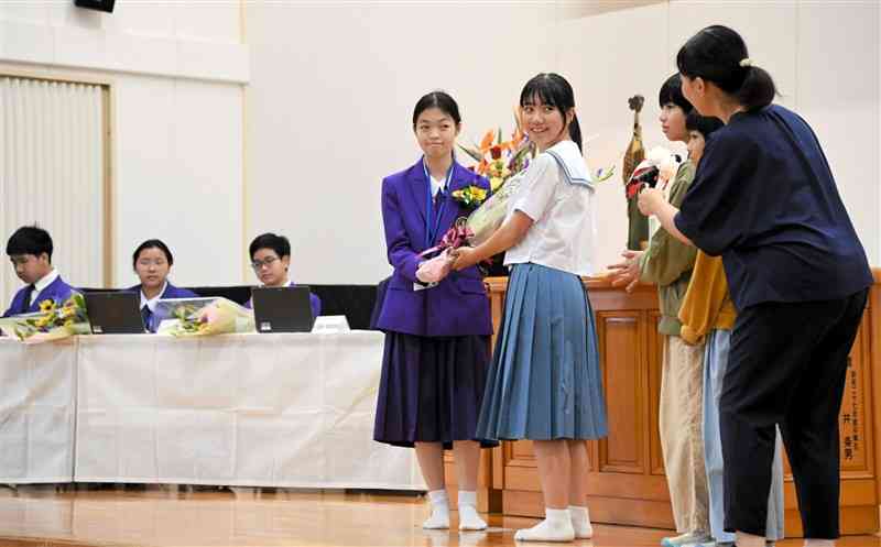 タイの中学生に花束を渡すホストファミリーとなる産山学園の生徒ら＝産山村