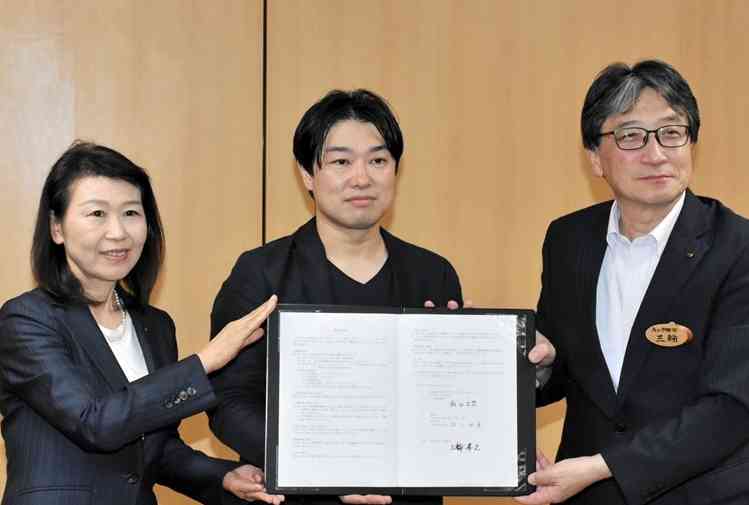 熊本市と立地協定を結んだアルキアの飯田広哲社長（中央）ら＝26日、県庁