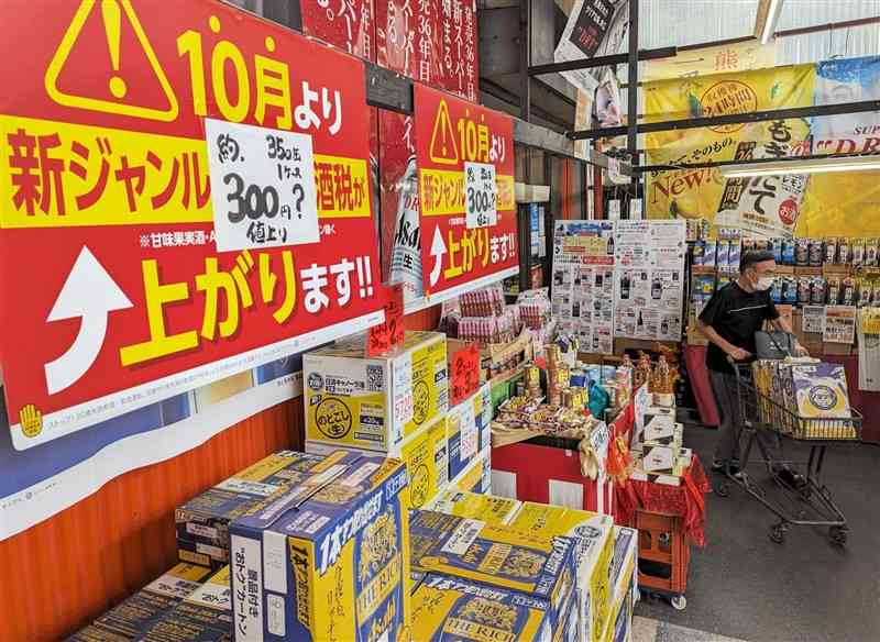 第三のビールの値上げを知らせるアカツキ酒店の売り場。まとめ買いする客が次々に訪れる＝28日、熊本市北区