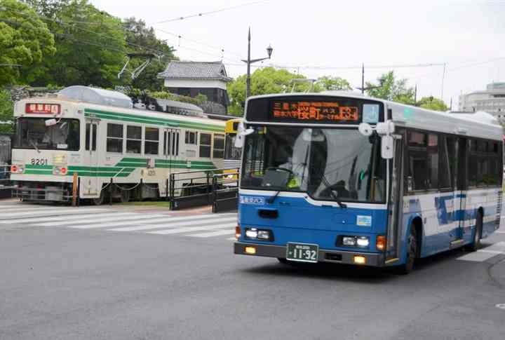 熊本市中心部を走るバスと市電＝同市