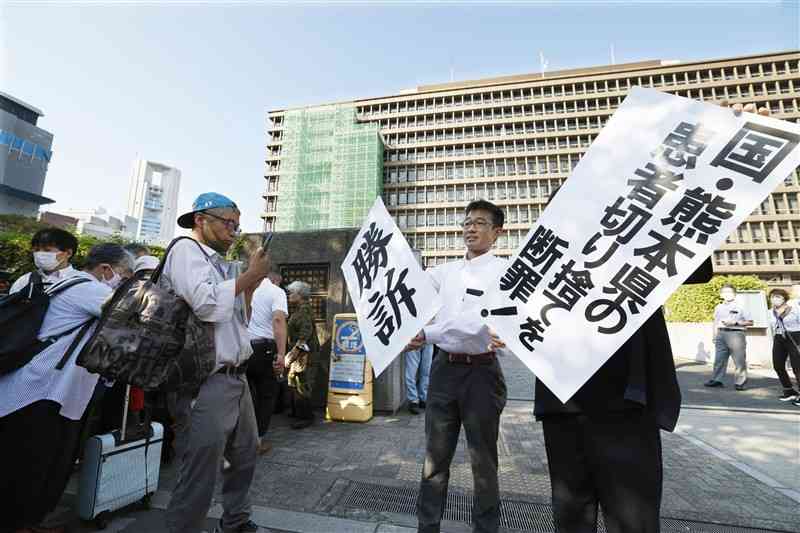 大阪地裁判決を受け、「勝訴」などと書かれた紙を掲げる弁護士ら＝9月27日、大阪市