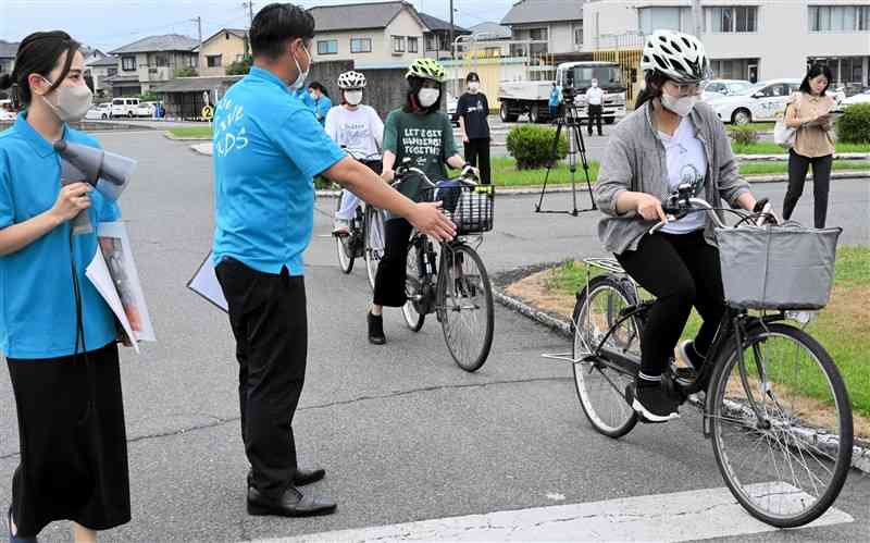 自転車に乗って日本の交通ルールを学ぶ参加者＝菊池市