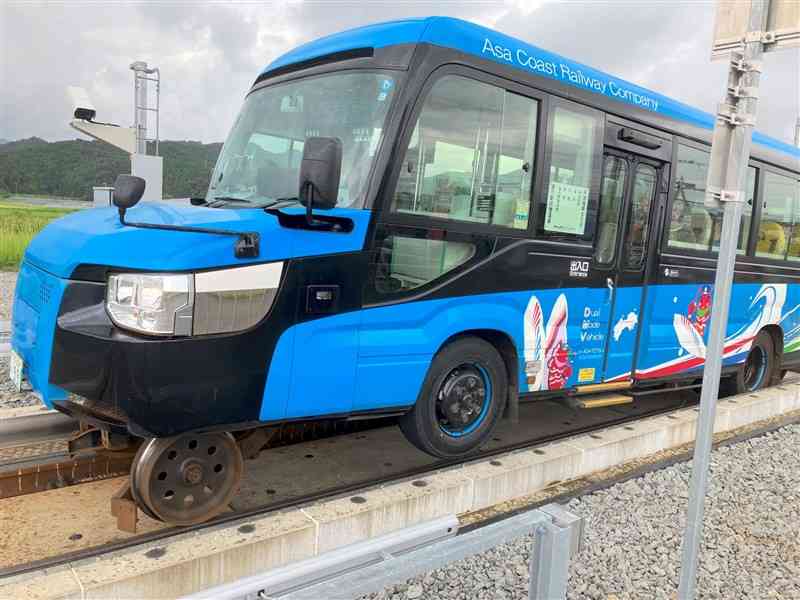 バスから鉄道へモードチェンジ中のDMV。鉄車輪が下りてゴムタイヤが浮かんでいく＝徳島県海陽町