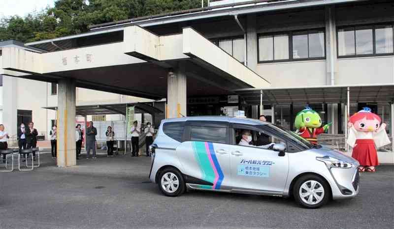 関係者に見送られ、最初の乗客を迎えに出発する「栖本地域乗合タクシー」＝2日、天草市