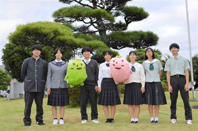校庭にある大きな松の木の前に立つ松橋高の生徒たち。黄緑色のぬいぐるみは生徒会公認キャラクター「まつぴん」。ピンクは「まつぴん子」