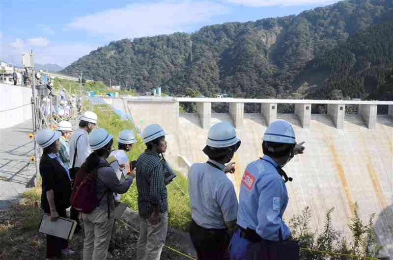 立野ダムを視察する県の環境影響評価審査会の委員ら＝5日、南阿蘇村
