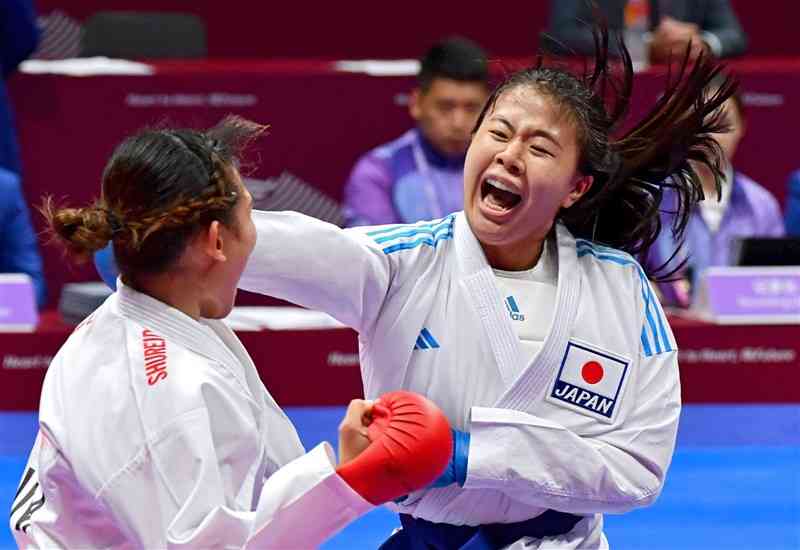 【空手女子組手68キロ級準々決勝】上段突きを放つ釜つばさ（右、同大）＝臨平スポーツセンター体育館（石本智）