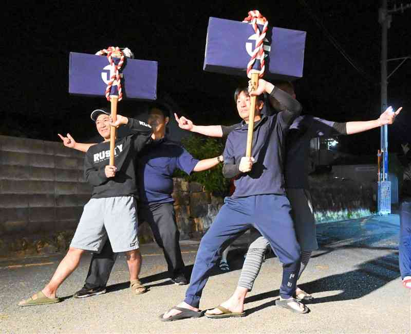 奴踊りの練習で、鋏箱を掲げてポーズを決める江樋戸地区の男性たち＝上天草市