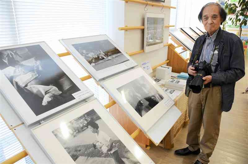 桑原史成さん（右）が1960年代から手がけてきた水俣病関連の写真が並ぶ企画展＝11日、東京都渋谷区