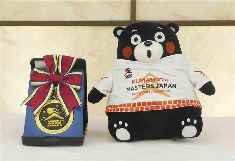 バドミントン国際大会「熊本マスターズ」の優勝者に贈呈する「肥後象がん」で熊本城を表現した金メダル（左）と副賞の「くまモン」のぬいぐるみ＝17日午後、熊本市