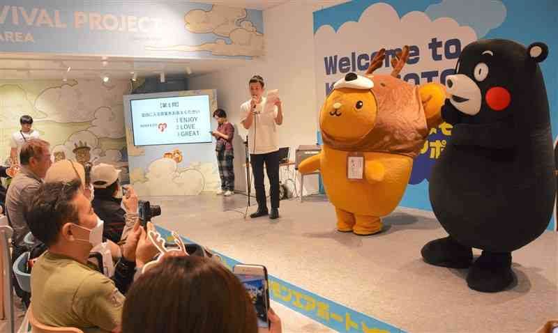 熊本空港であった北海道の観光PRイベント。道の観光PRキャラクター「キュンちゃん」（中央）とくまモン（右端）によるステージイベントもあった＝21日、益城町