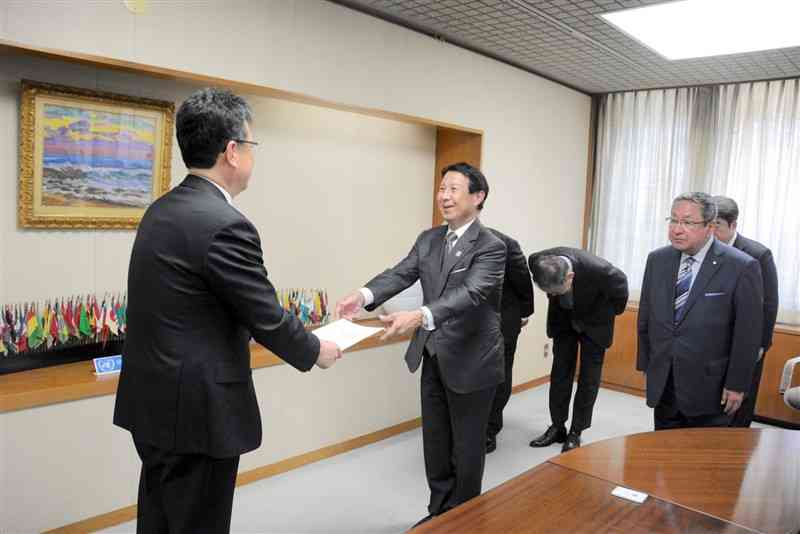 大西一史熊本市長（左）に要望書を手渡す熊本経済同友会の笠原慶久代表幹事＝23日、市役所