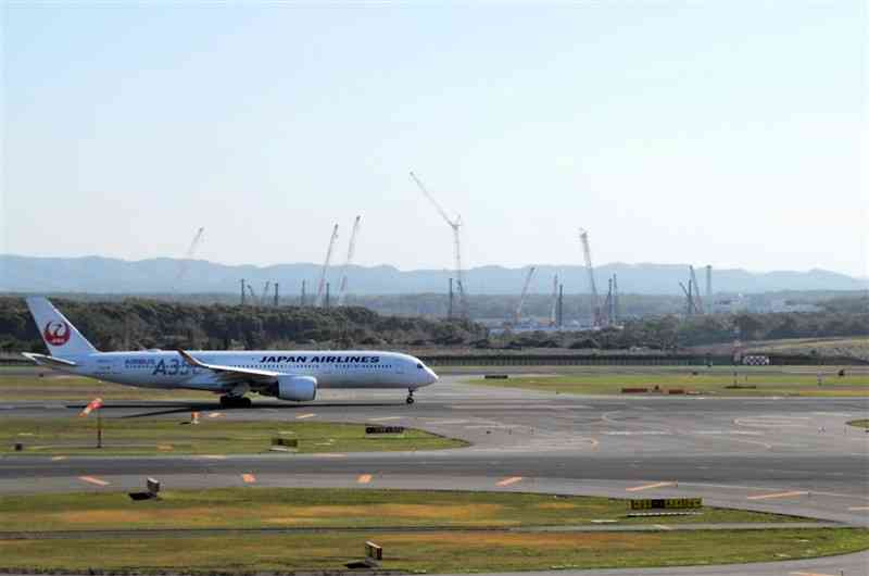 新千歳空港から見える「ラピダス」の工場建設地（奥）。基礎工事のクレーンがいくつも伸びている＝13日、北海道千歳市