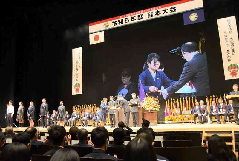 プロジェクト発表で最優秀賞を受賞し、表彰状を受け取る熊本農高の生徒＝26日、熊本市中央区