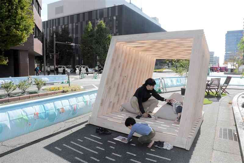 車両通行止めにした市民会館前の市道で遊ぶ親子＝28日、熊本市中央区