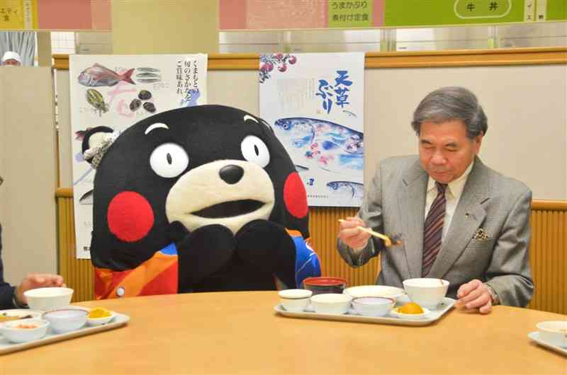 県産水産物の消費拡大を促すため、県産養殖ブリの煮付けを食べる蒲島郁夫知事＝30日、県庁