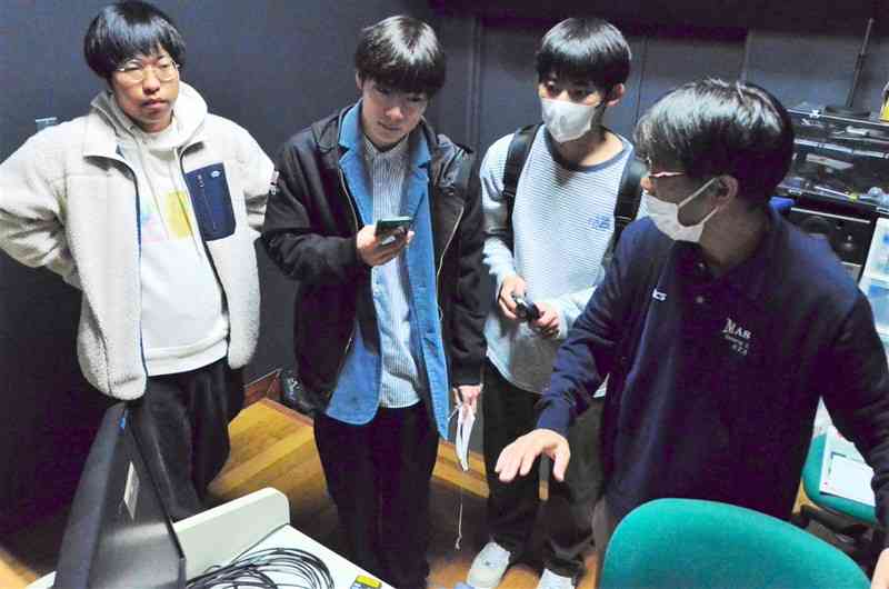 11月4日の上映会を前に、機材をチェックする実行委員の（左から）坂本昂陽さん、森崇さん、吉山昇汰さん＝28日、益城町