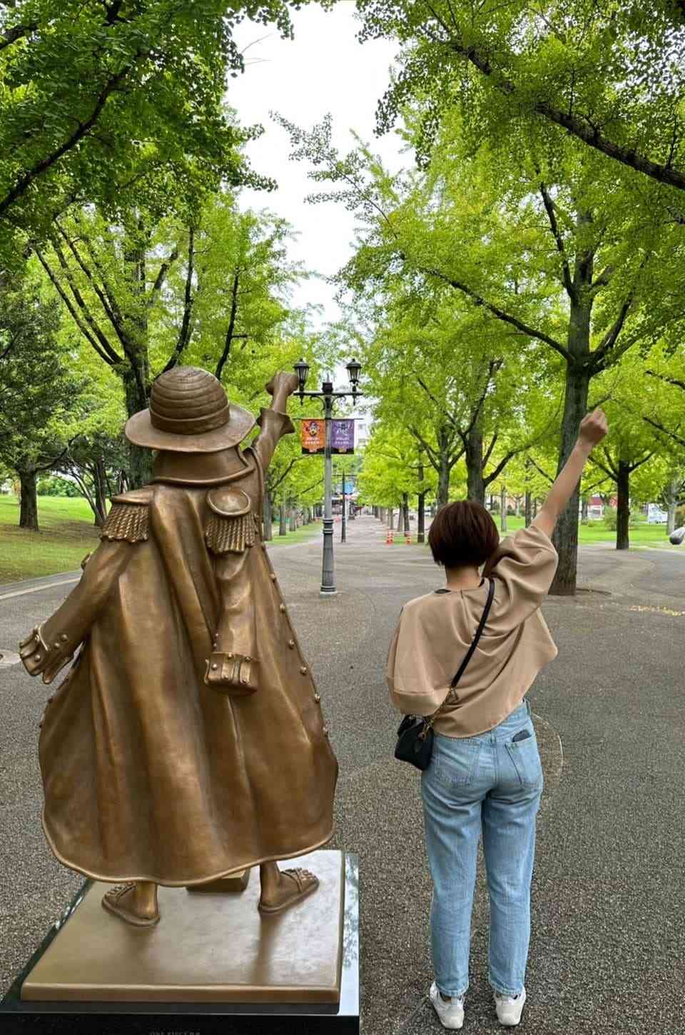 「ワンピース　熊本復興プロジェクト」で熊本県庁のプロムナードに設置された主人公・ルフィの像と記念撮影をする施さん
