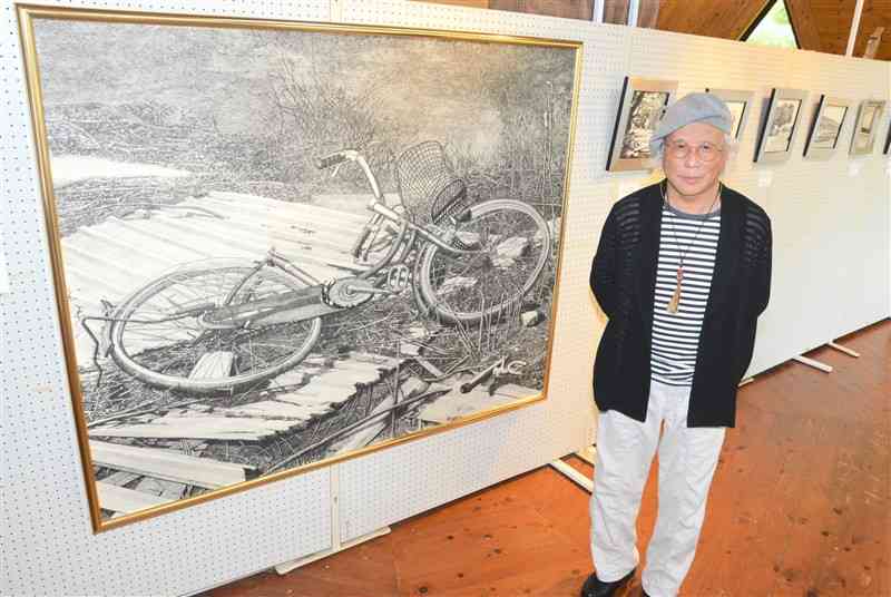 4年ぶりの個展を開いたペン画家の西川誠一さん。捨てられた自転車を描いた100号のほか、会場には近作の風景画が並ぶ＝9月下旬、山鹿市