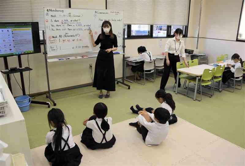 外国人講師から英語の授業を受ける子どもたち＝10月、熊本市南区