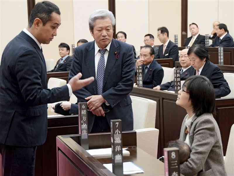 熊本市議会の澤田昌作議長（左）らに説得される緒方夕佳議員（右手前）＝2017年11月、熊本市議会棟