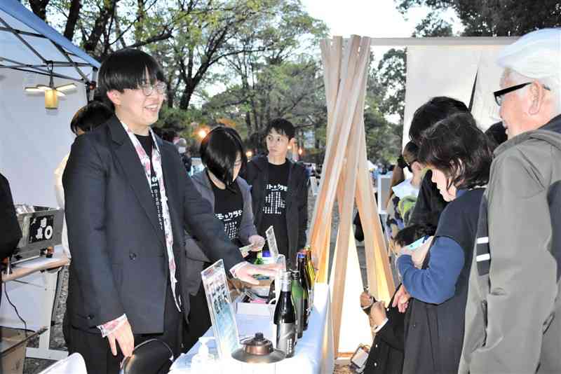 日本酒を炭酸水などで割る飲み方を提案する熊本大の学生（左）ら＝10月28日、熊本市中央区