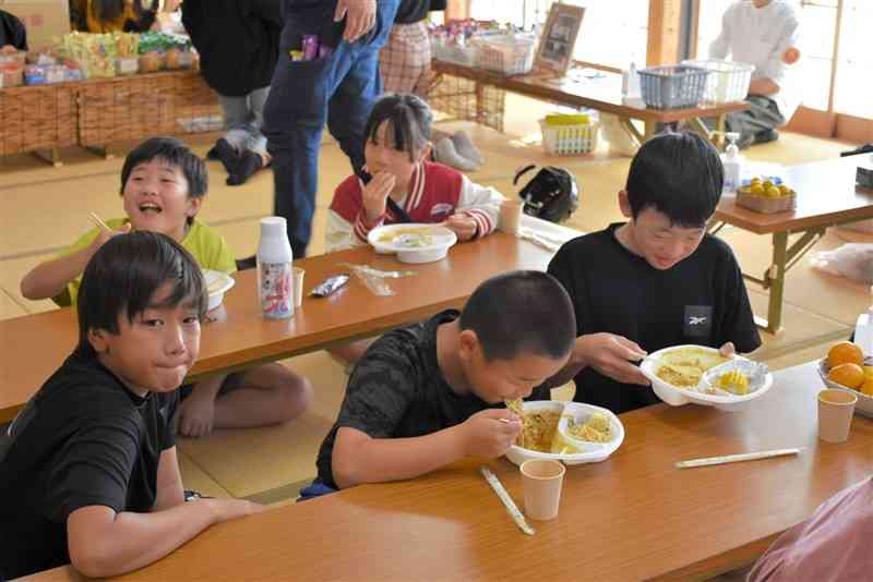 農家や店などから提供された材料で作った食事を頰張る児童ら＝10月29日、熊本市北区