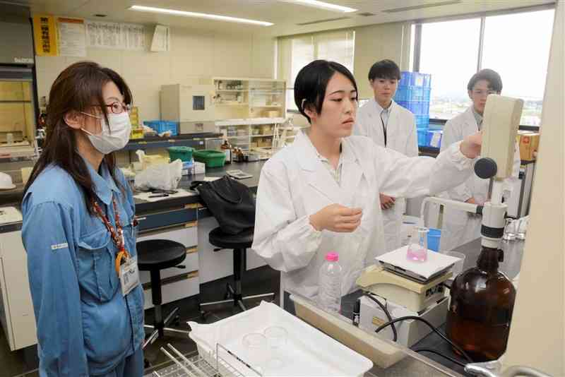 熊本市のインターンシップで、職員（左）の指導を受けながら地下水の水質を調べる大学生＝8月、東区の市環境総合センター