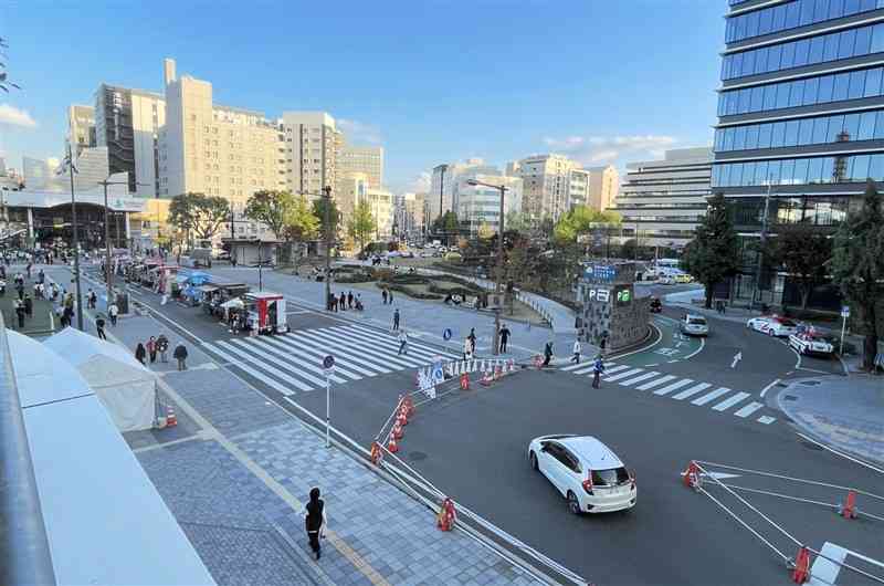 延長80メートルを通行止めにして歩行者空間化した辛島公園北側の市道。イベントなどでにぎわう一方、渋滞やバスの遅延を指摘する声もある＝28日、熊本市中央区