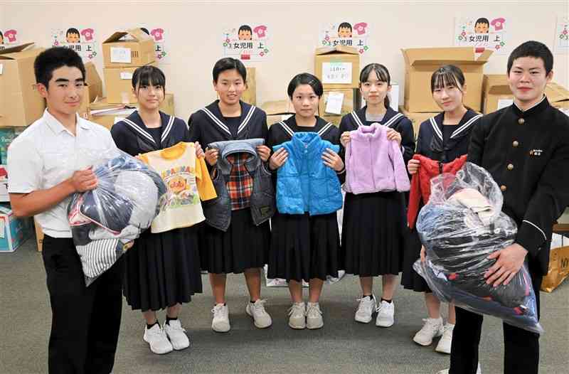 集めた子ども服を菊池市役所に持参した菊池南中の生徒たち＝2日、菊池市