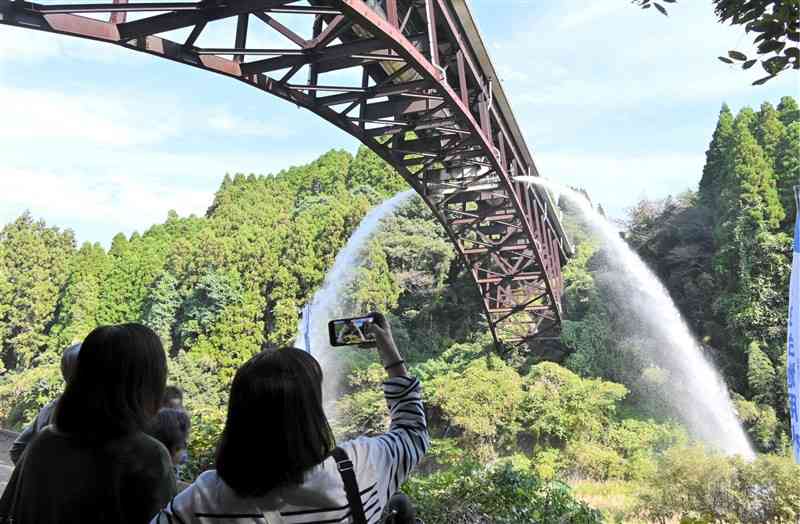 年1回の放水で豪快なアーチを描く豊潤橋＝4日、菊池市