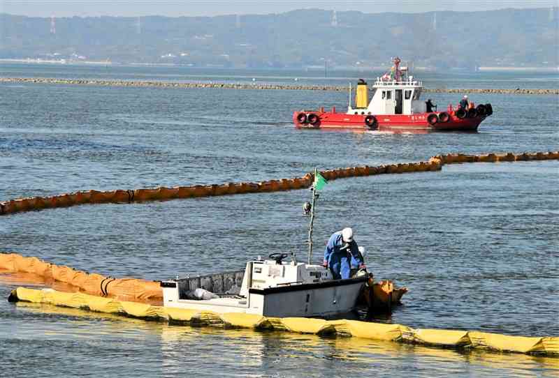 災害を想定した合同訓練でオイルフェンスを広げる船舶＝7日、八代市大島町