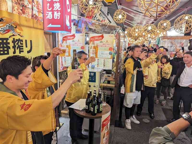 熊本屋台村でビールを片手に乾杯する関係者と来店客＝10日、熊本市中央区