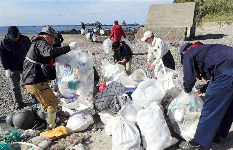 無人島の大島で、漂着ごみを集める参加者たち＝11日、天草市