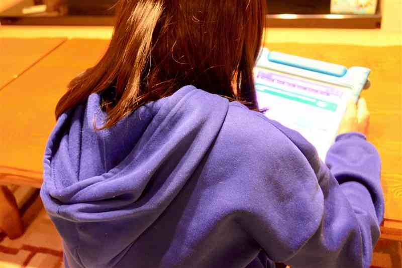 学校貸与の学習用タブレットを使う女児。一部の子どもたちの長時間利用が問題になっている＝熊本市