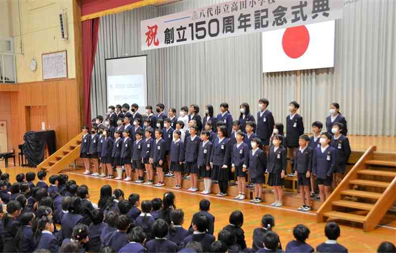 高田小の創立150周年記念式典で学習成果を発表する児童たち＝18日、八代市