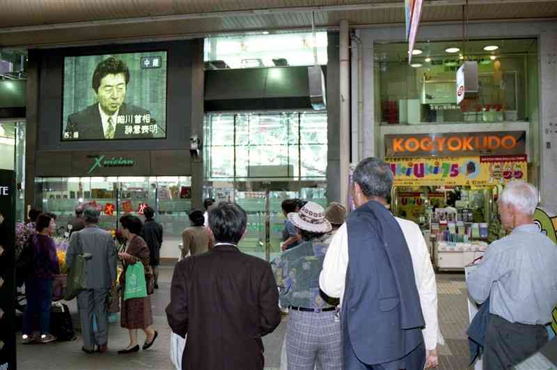 細川護熙首相の退陣会見を立ち止まって見る人たち＝1994年4月8日午後3時20分ごろ、熊本市上通アーケード