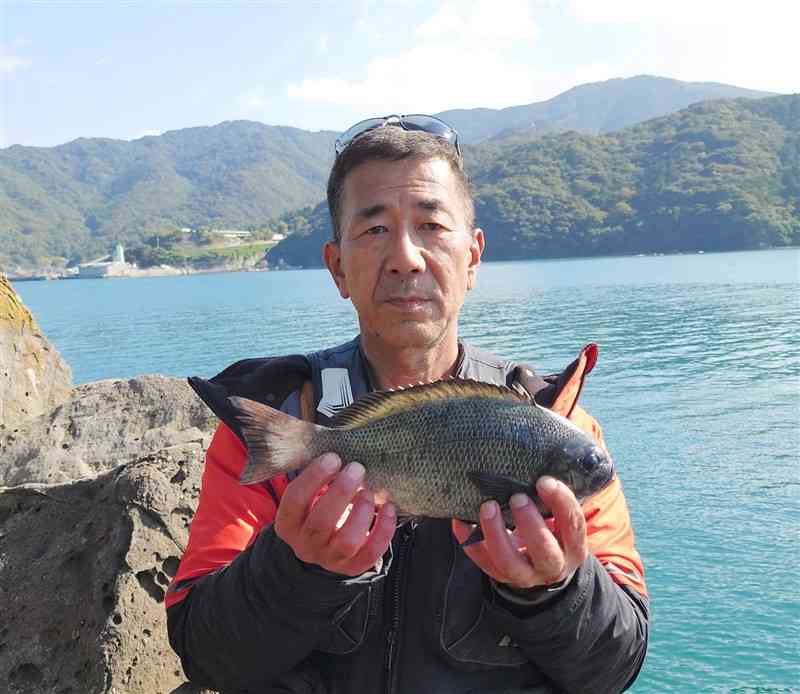 タナを微調整し揚げた34センチのクロを持つ鍋島一浩さん＝天草市御所浦町