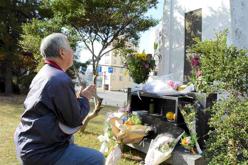 大洋デパート火災の慰霊碑に手を合わせる元従業員の府内登志光さん＝29日、熊本市中央区