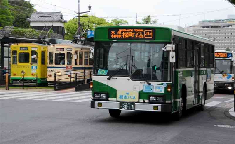 熊本市中心部を走るバスと市電＝同市