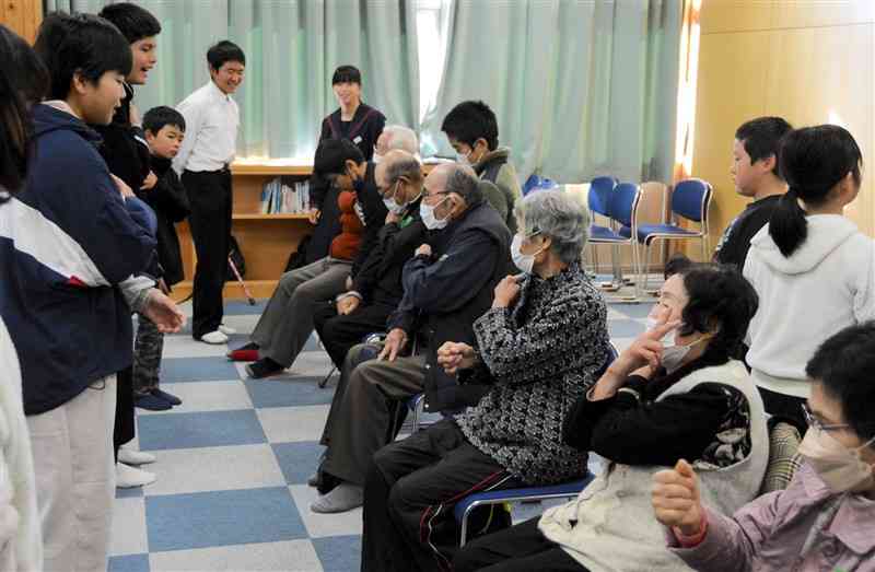 認知症予防の体操で交流する産山学園生と高齢者ら＝28日、産山村