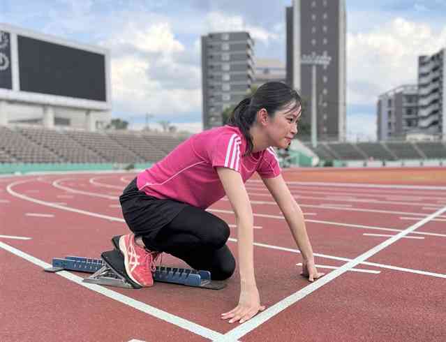 思い出の残るスタジアムで、12年ぶりに100メートル走のスタートラインに構える東有咲記者＝9月、熊本市中央区