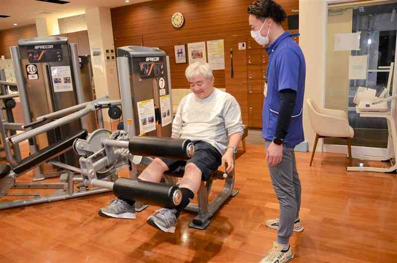 理学療法士の指導で心臓リハビリテーションに取り組む工藤健太郎さん（左）＝熊本市中央区
