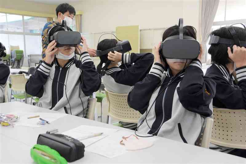 仮想現実（VR）で認知症患者が見る世界を体験する芦北高の生徒＝5日、芦北町