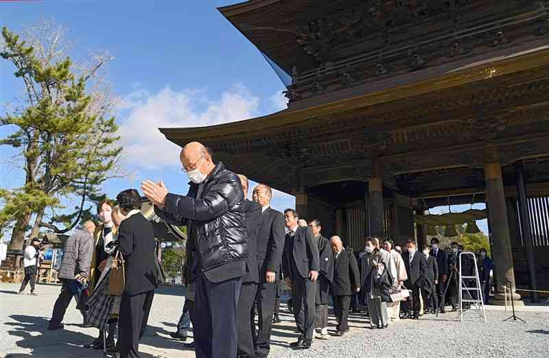 熊本地震からの復旧工事が完了した阿蘇神社の楼門の通り初めをする参拝客ら＝7日午後0時40分ごろ、阿蘇市（石本智）