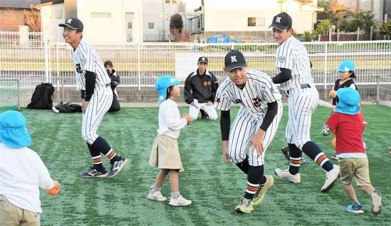 城山幼稚園の園児たちとボールを当てる鬼ごっこを楽しむ熊本西高野球部の部員ら＝７日、熊本市西区